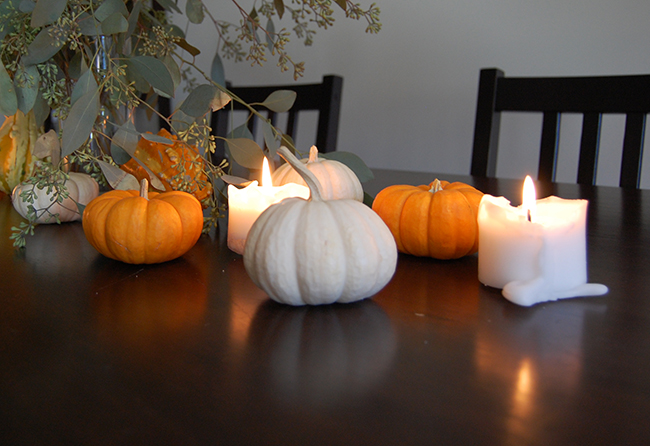 minimalist halloween decor and halloween tablescape using pumpkins, candles, and construction paper bats