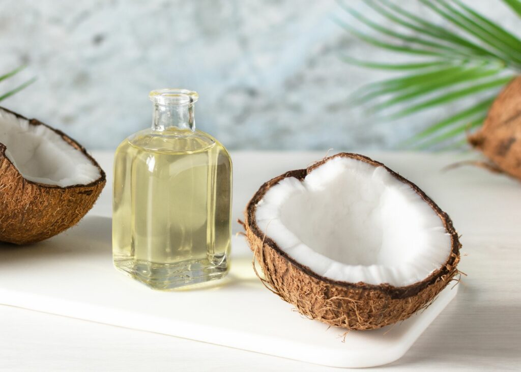 Bottle of coconut oil and fresh coconuts - How to get coconut oil out of clothes