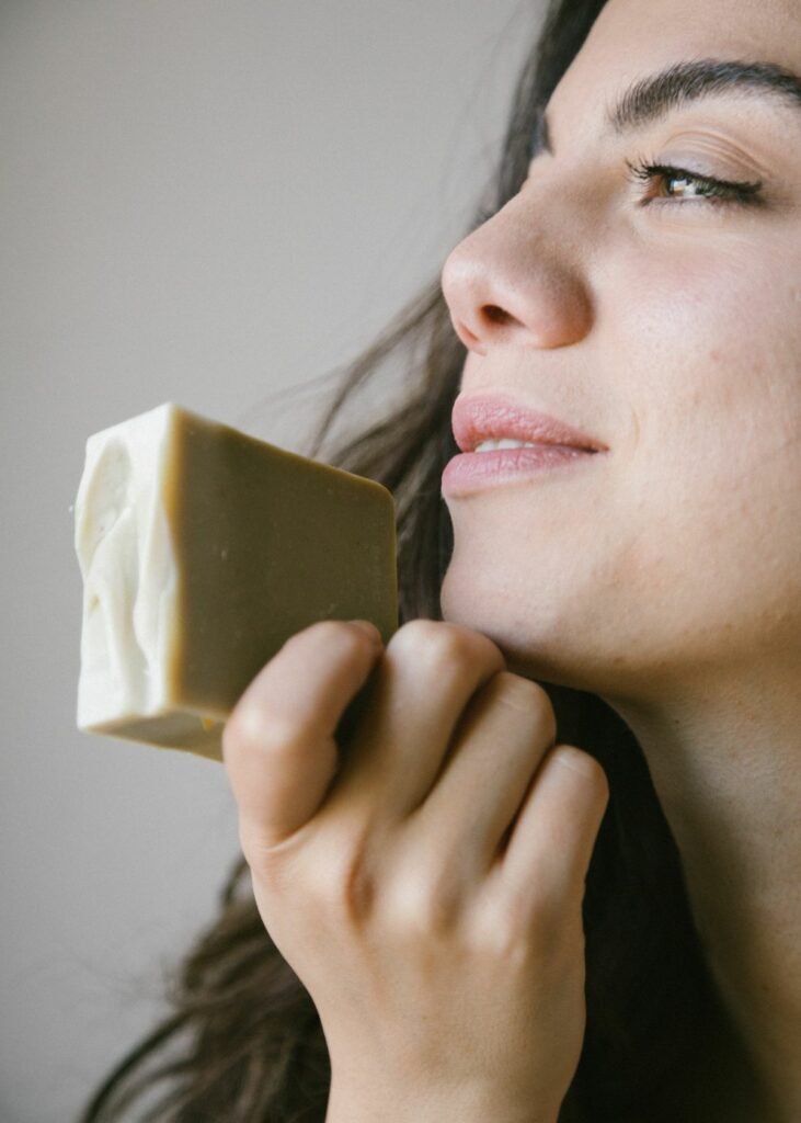 A woman holding a soap bar - How to wash your face with bar soap
