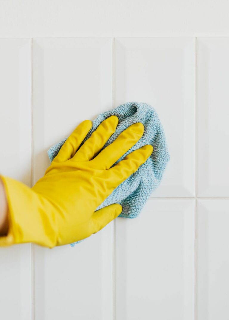 Person cleaning shower tiles - How to Clean Shower Tiles Without Scrubbing